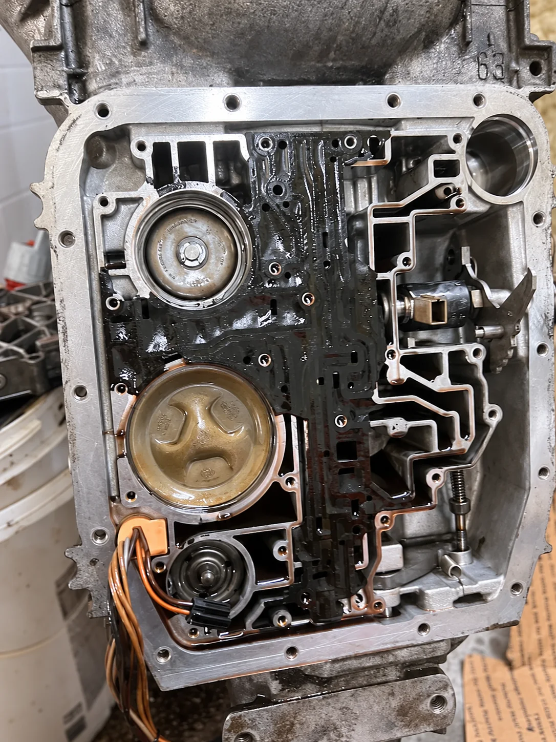 Opened transmission case showing internal passages, circular assemblies and wiring